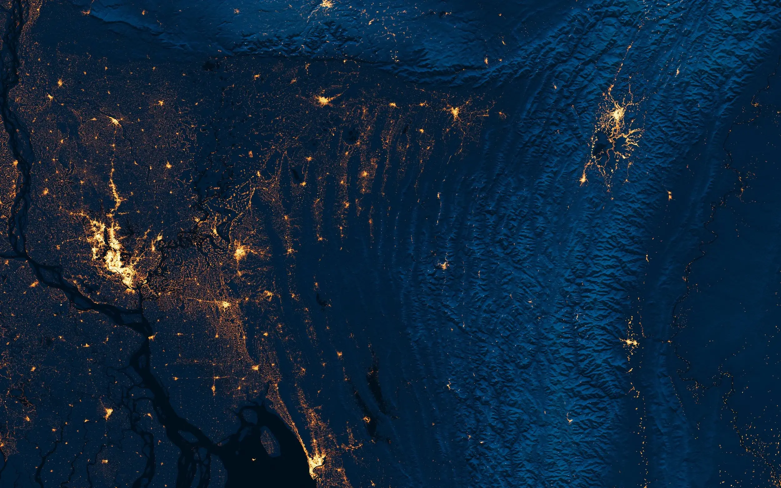 Satellite view of Dhaka region at night showing urban lights and terrain
