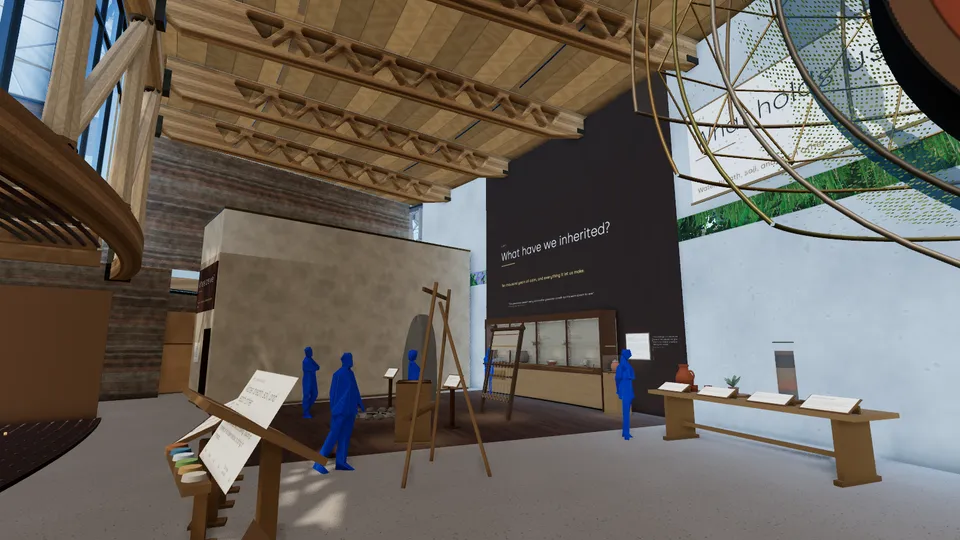 The exhibition: objects on tables and stands, a wall of text and visitors among them.